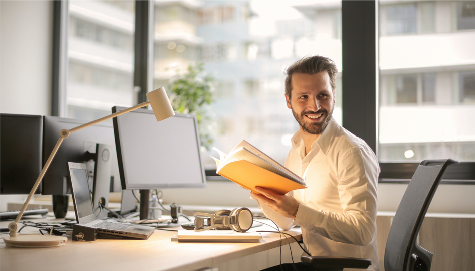 Smiling man at computer desk | Employee Assistance Plan | Benefits by Design