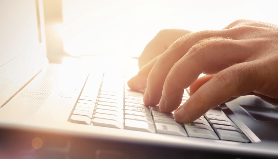 Hands typing on a keyboard