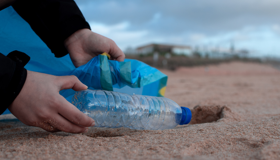 Plastic bottle on sand beach | Volunteering | Benefits by Design