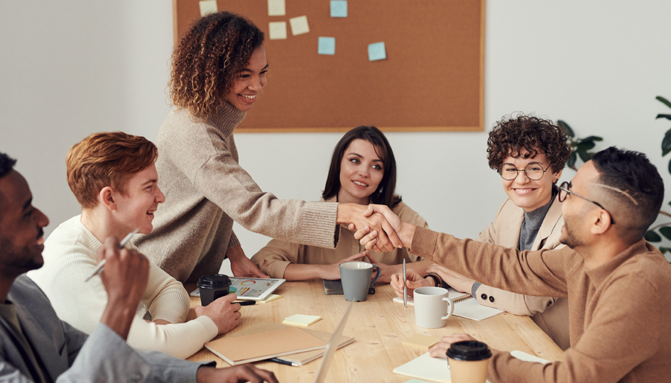 Happy employees shaking hands | Fully-Insured | Benefits by Design