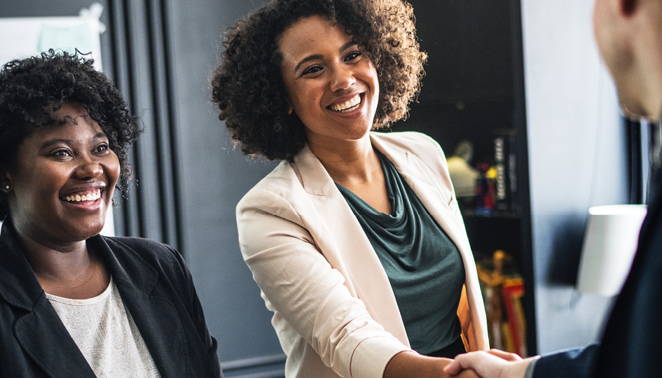 Woman shaking hands | Employee Benefits | Benefits by Design