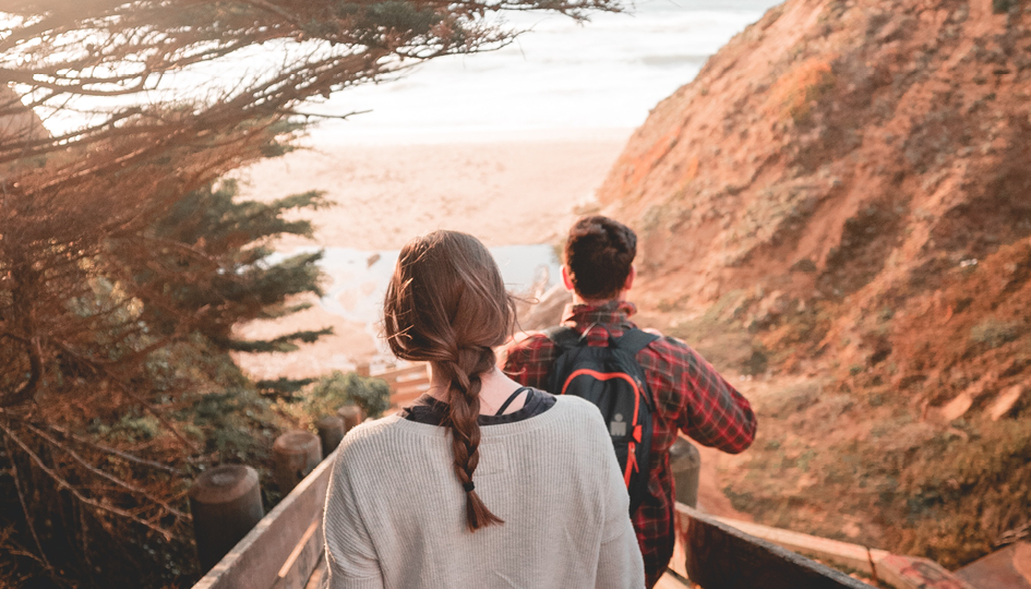 Two people walking on a beach | Vacation | Benefits by Design