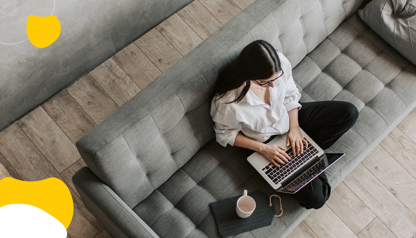 Woman on couch using laptop | Short Term Disability | Benefits by Design