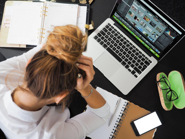 stressed woman at work sitting at the laptop