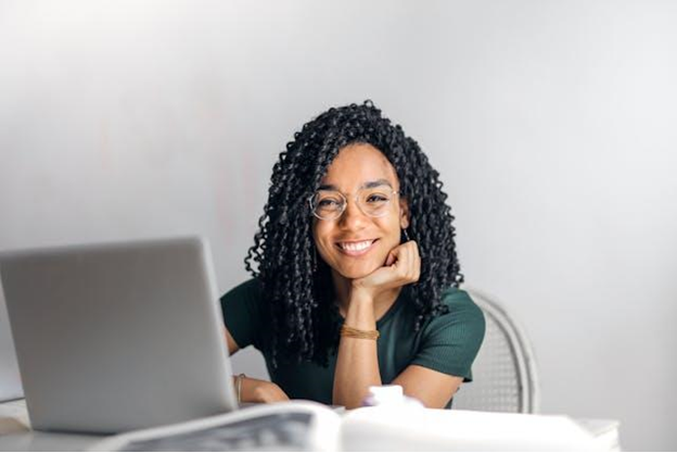 A woman sitting in front of her laptop and smiling